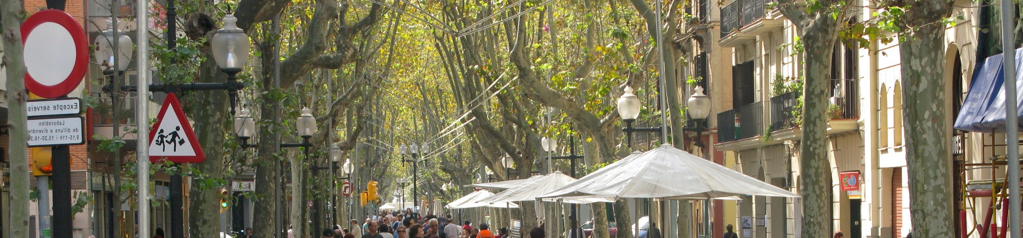 Calle arbolada con terrazas y ambiente urbano en Poblenou, Barcelona